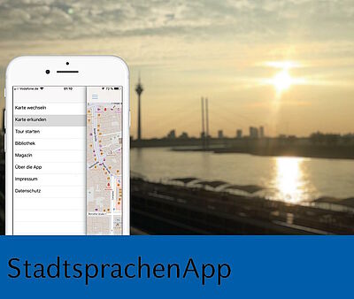 Handy mit App vor Düsseldorfer Promenade